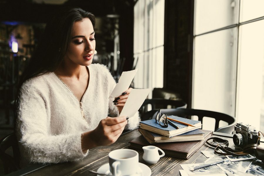 A pen resting on a handwritten net worth statement next to a stack of asset statements