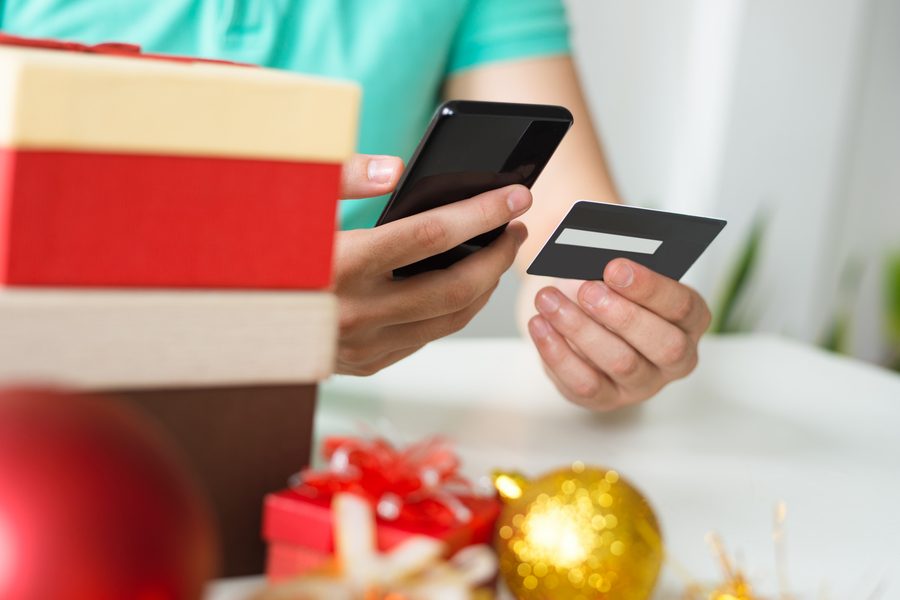 Person using laptop with shopping cart and phone showing cash-back app earnings