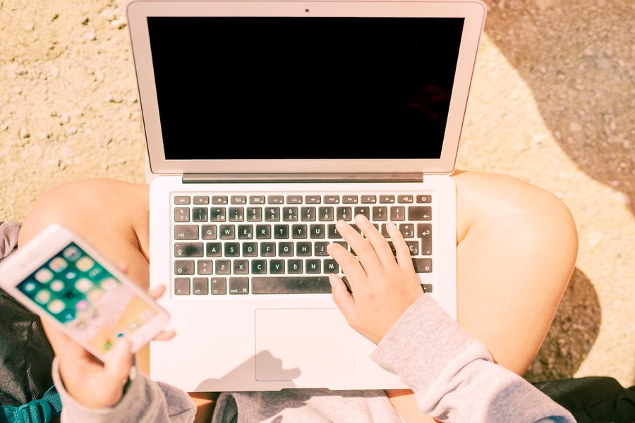 Digital nomad reviewing a compliance checklist and calendar of travel days on a laptop