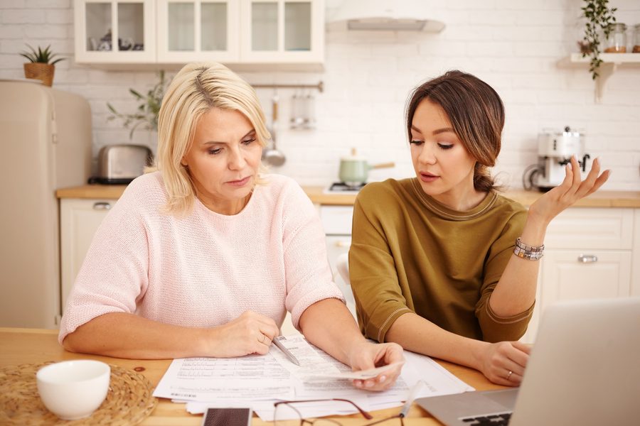 A woman checking her finances on a laptop with a modern fintech dashboard