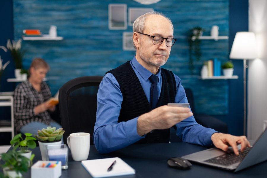 A retiree uploading a bank statement PDF to ChatGPT on a laptop