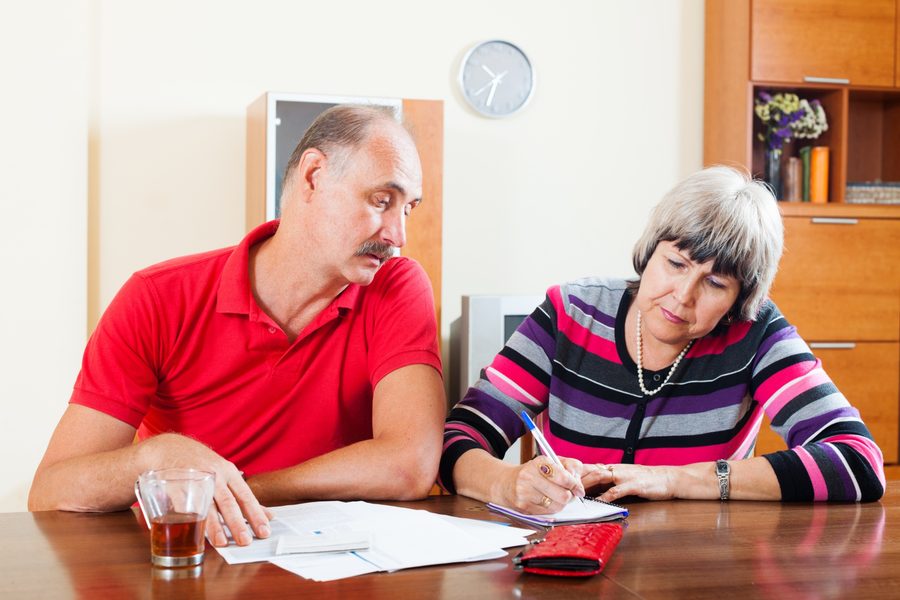 Hands sorting financial documents with tax statements visible