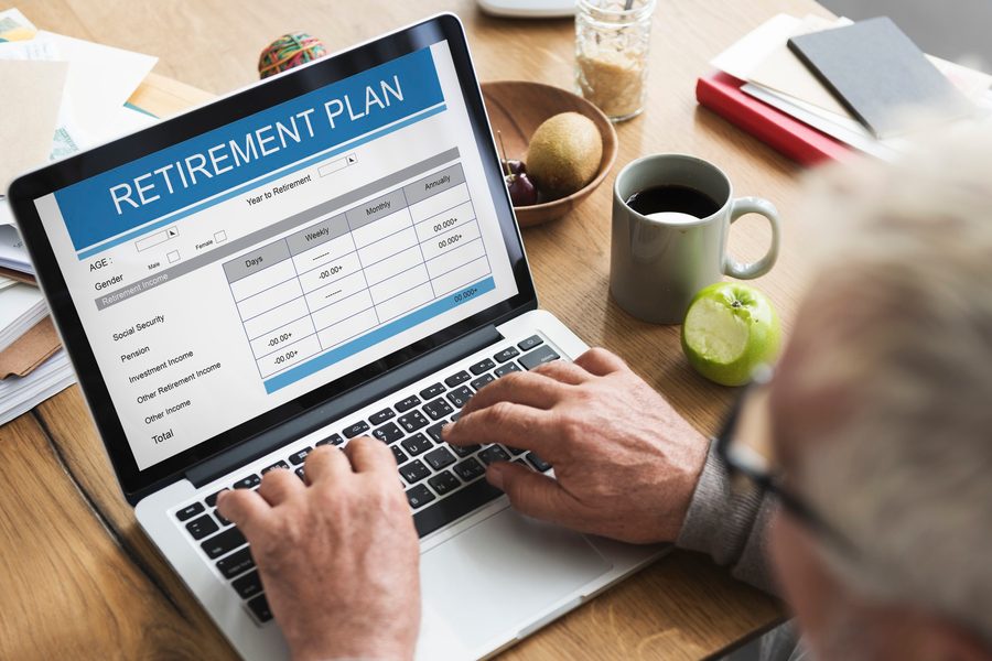 Gig worker on a laptop reviewing retirement account choices with a calendar and tax forms nearby