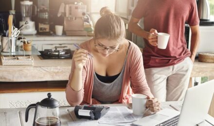 Person reviewing spreadsheet with side hustle income and tax documents on desk