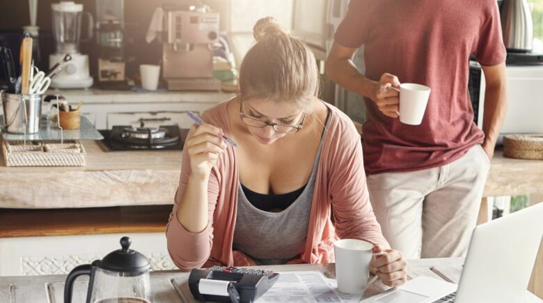 Person reviewing spreadsheet with side hustle income and tax documents on desk