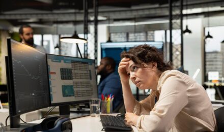Person reviewing budget spreadsheet with financial data and charts showing overspending patterns