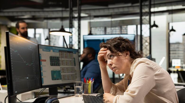 Person reviewing budget spreadsheet with financial data and charts showing overspending patterns